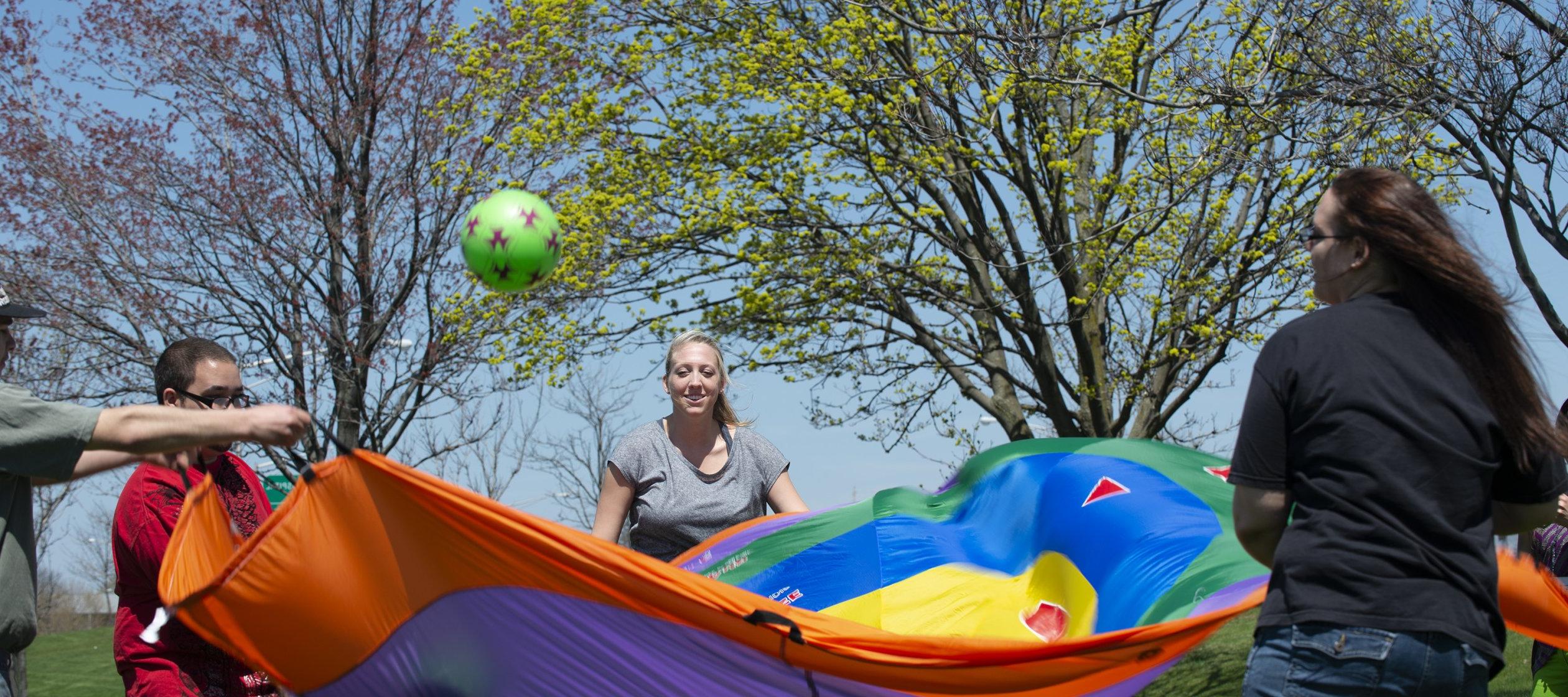 职业治疗专业的学生带着降落伞和球工作.