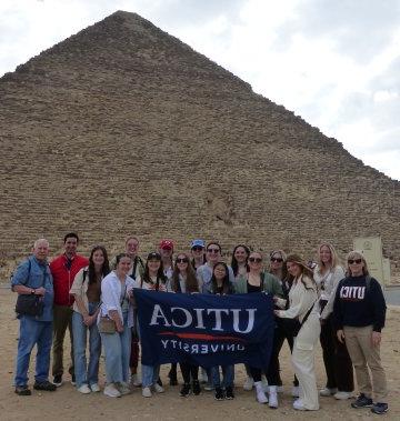 2023年1月访问埃及期间，学生和教师在大金字塔前举起了利记sbo的横幅.
