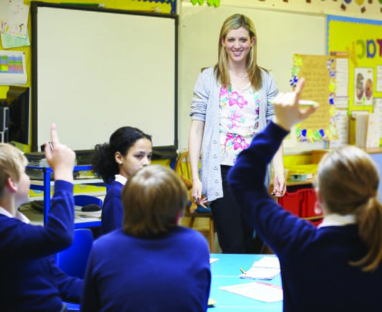 老师在教室里与学生一起举手.